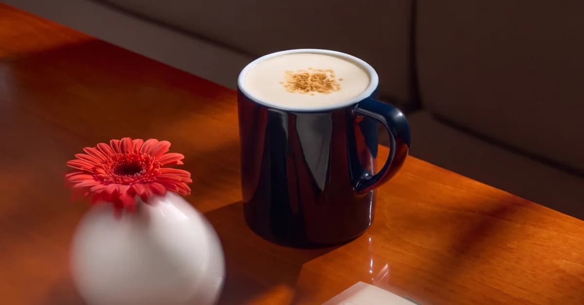 Креатив Coffeemania для Google Ads: раф в синей кружке и гербера на деревянном столе
